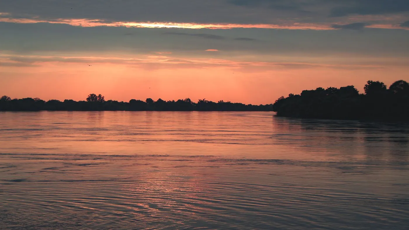 the Godavari at sunset, the water red under a dark treeline