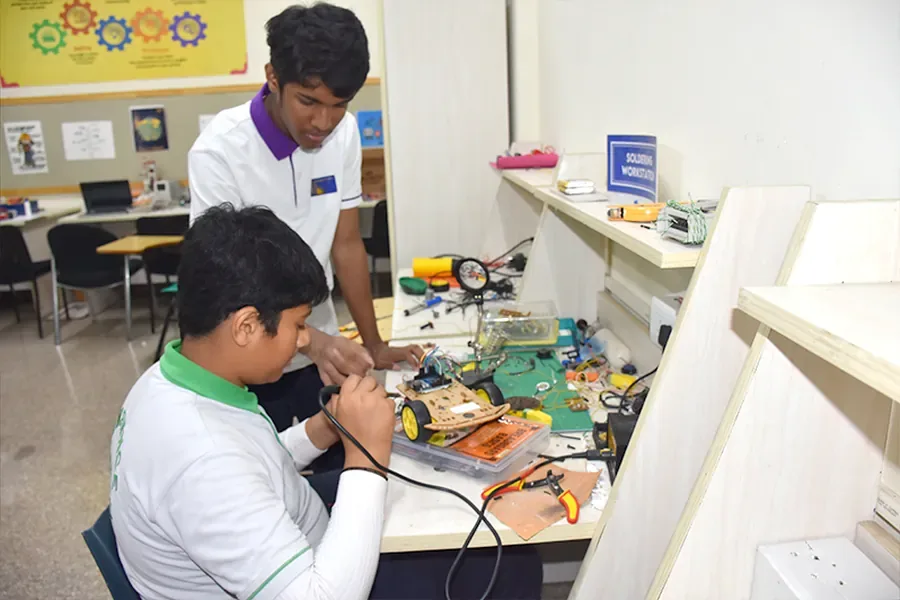 Students building in the robotics lab, as featured in the Quantum Quest section